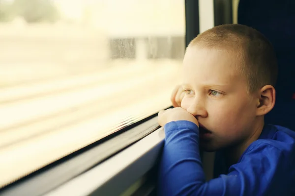 Ragazzo guardando attraverso la finestra — Foto Stock