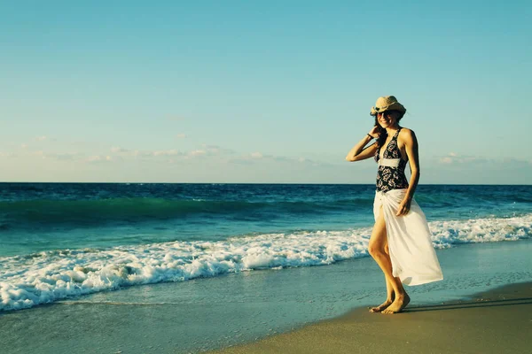 Frau geht am Strand spazieren — Stockfoto