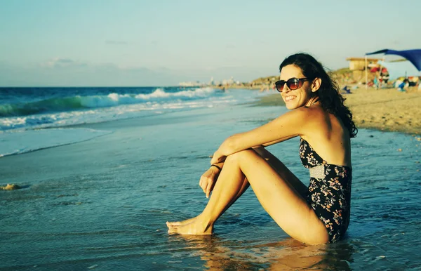 Mujer sentada en la playa — Foto de Stock