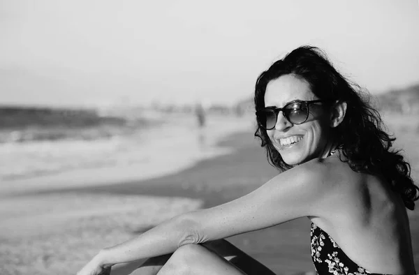 Vrouw zitten op het strand — Stockfoto