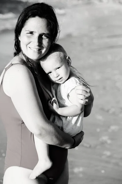 Portret van gelukkig liefhebbende moeder en haar baby op het strand — Stockfoto