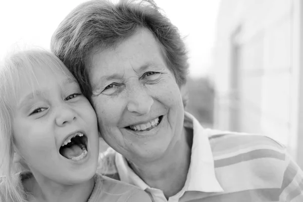 Portrait of beautiful 70 years old woman with 5 years old granddaughter — Stock Photo, Image