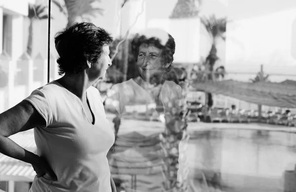 Mujer mirando a la ventana — Foto de Stock