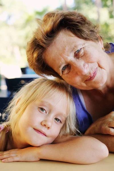 Portrait of beautiful 70 years old woman with 5 years old granddaughter — Stock Photo, Image