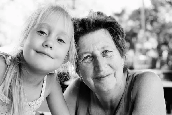 Portrait of beautiful 70 years old woman with 5 years old granddaughter — Stock Photo, Image