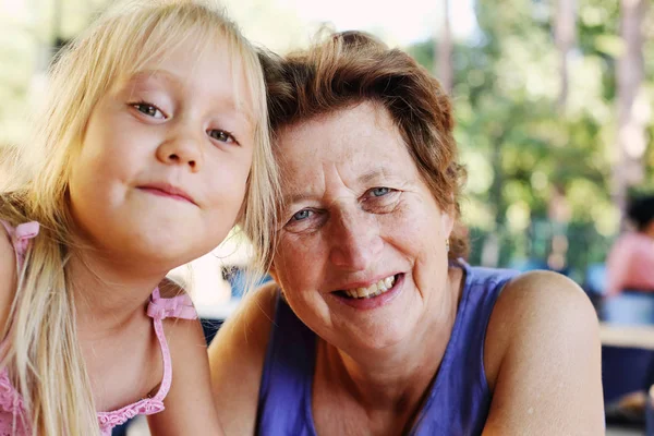 Retrato de una hermosa mujer de 70 años con una nieta de 5 años —  Fotos de Stock