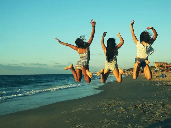 Trzy dziewczyny skoki na plaży — Zdjęcie stockowe