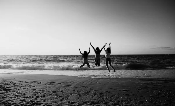 在沙滩上跳跃的三个女朋友 — 图库照片
