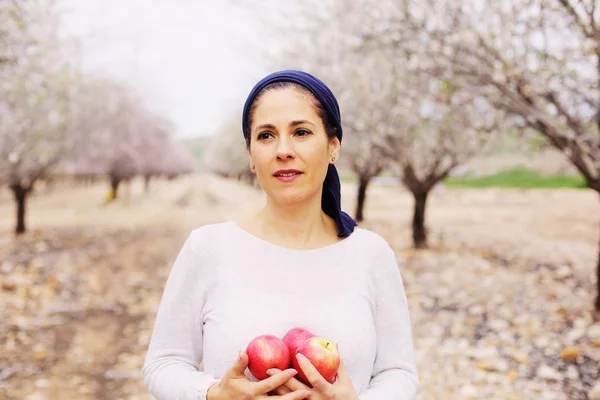 Starsza kobieta trzyma czerwone jabłka — Zdjęcie stockowe