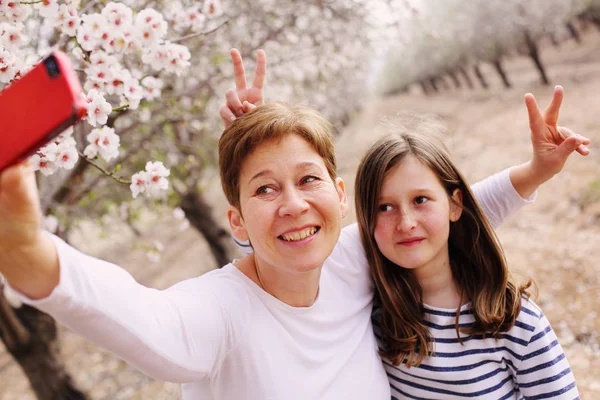 Mor och dotter i blommande park — Stockfoto