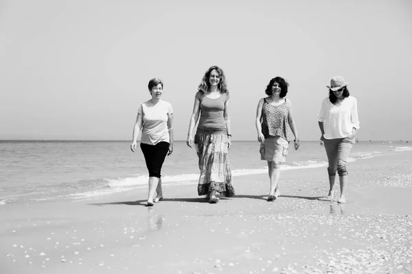 Mujeres maduras caminando en la playa —  Fotos de Stock