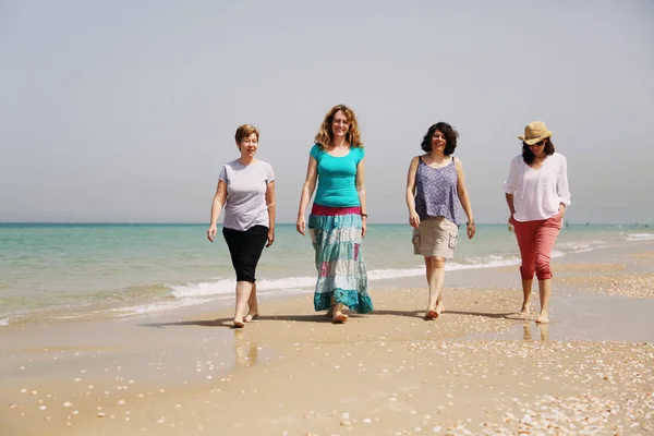 Rijpe vrouwen lopen op zee — Stockfoto