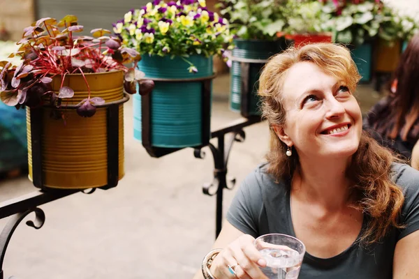 Зрелая женщина сидит в кафе на открытом воздухе — стоковое фото