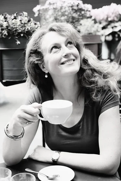 Mature woman sitting in outdoor cafe — Stock Photo, Image