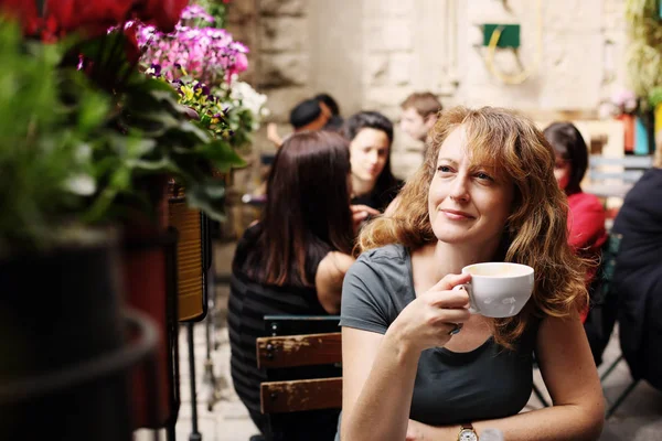 Mulher madura sentada no café ao ar livre — Fotografia de Stock