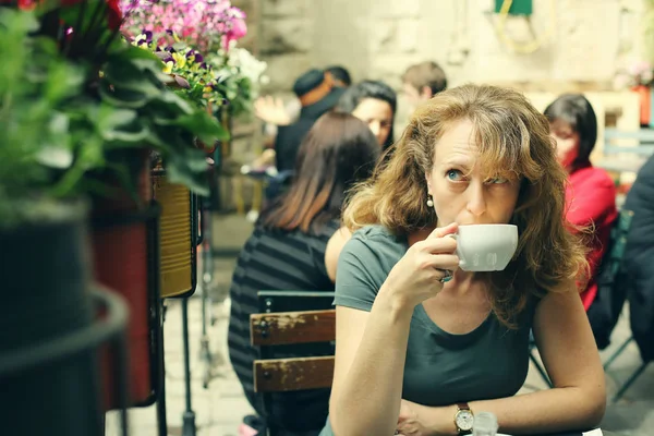 Rijpe vrouw zit op terras — Stockfoto