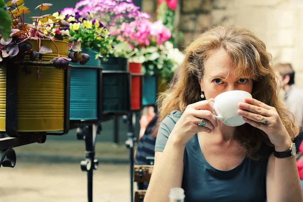 Femme mûre assis dans un café extérieur — Photo