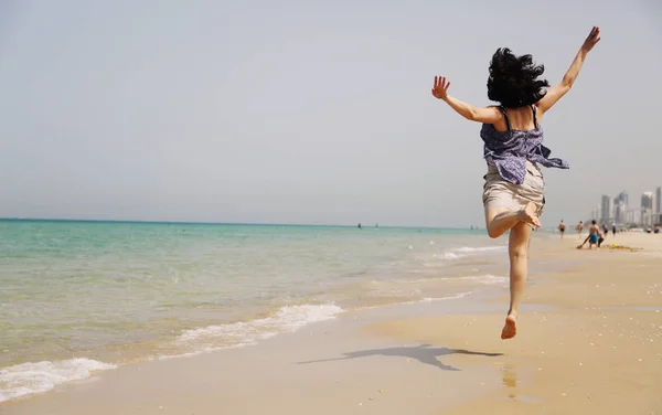 Olgun kadın kumsalda atlama — Stok fotoğraf