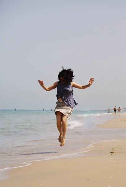 Reife Frau springt am Strand — Stockfoto