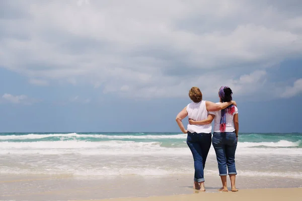 Mulheres em pé na praia arenosa — Fotografia de Stock