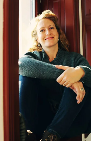 Mature woman sitting near window — Stock Photo, Image