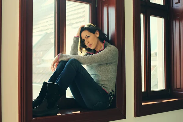 Traurige Frau blickt durchs Fenster — Stockfoto