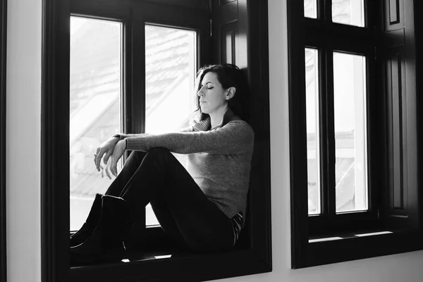 Sad woman looking throught window — Stock Photo, Image