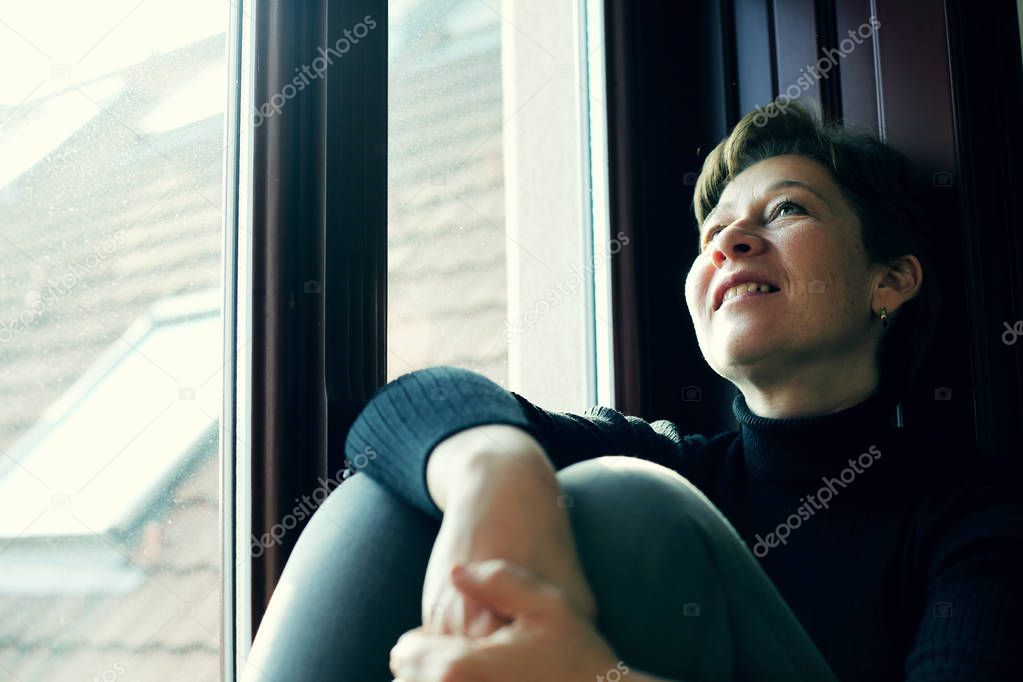 mature woman looking through window