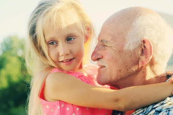 Grandfather holding granddaughter — Stock Photo, Image