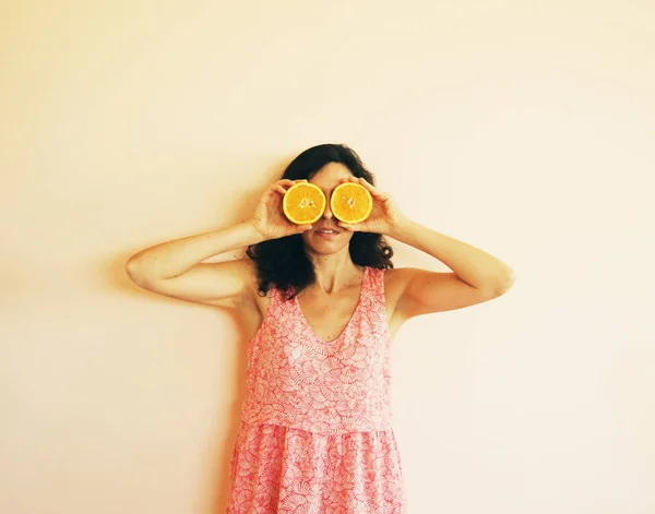 Mulher madura segurando fatias de laranja — Fotografia de Stock