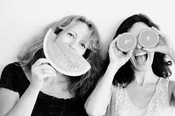 Women holding orange and watermelon — Stock Photo, Image