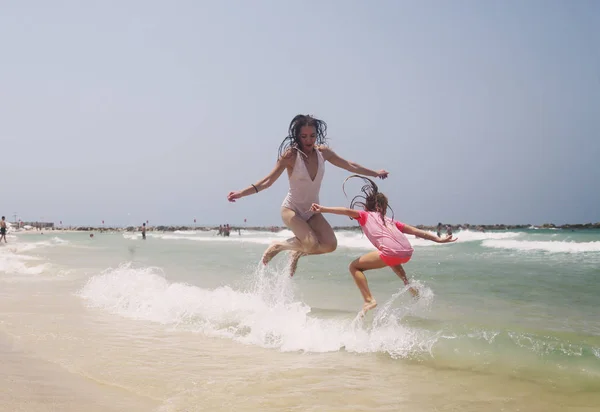 Meninas saltando à beira-mar — Fotografia de Stock