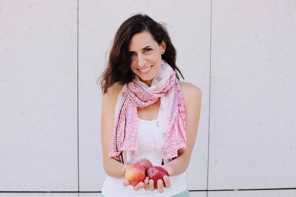 Beautiful woman is holding with freshly organic red apples — Stock Photo, Image