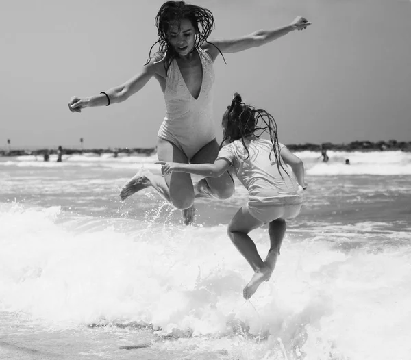 Chicas jóvenes saltando en la playa — Foto de Stock