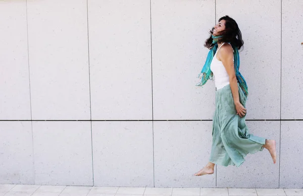 Portrait of smiling beautiful woman in turquoise skirt walking a — Stock Photo, Image