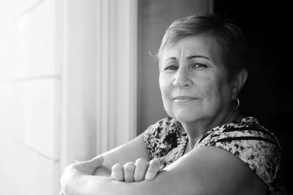 Senior kobieta siedzi na balkonie — Zdjęcie stockowe