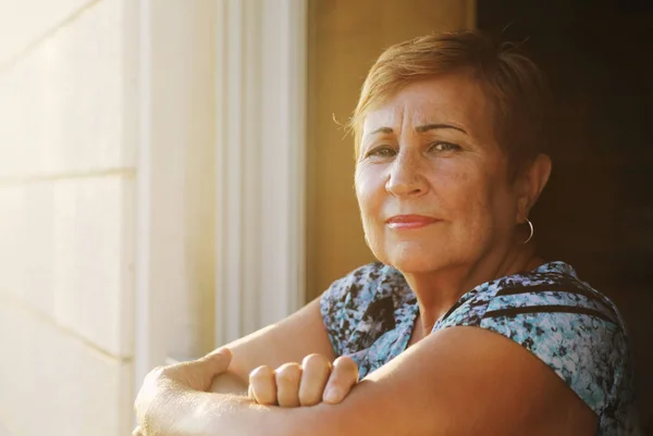 Senior vrouw zit op balkon — Stockfoto