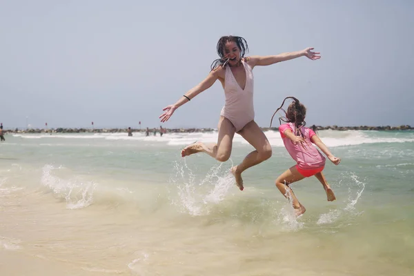 Jonge meisjes springen op zee — Stockfoto