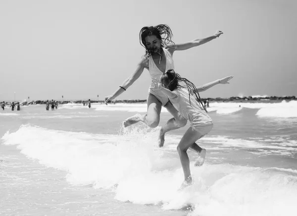 Young girls jumping on seaside — Stock Photo, Image