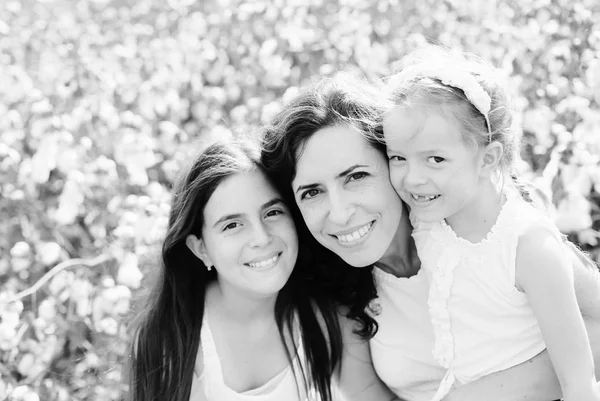Portrait of beautiful mother with two daughters outdoors — Stock Photo, Image