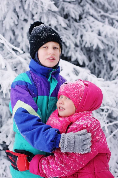 7岁女孩的冬天肖像与她的自闭症10岁的弟弟在户外 — 图库照片