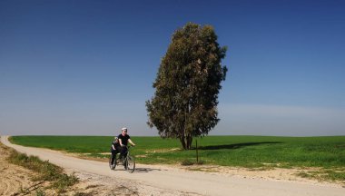 Baba ve oğul iki kişilik bisiklete binmek