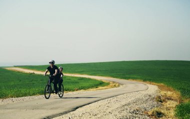 Baba ve oğul iki kişilik bisiklete binmek