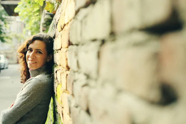 Mature woman near old wall — Stock Photo, Image