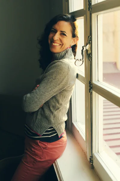 Volwassen vrouw in de buurt van venster — Stockfoto