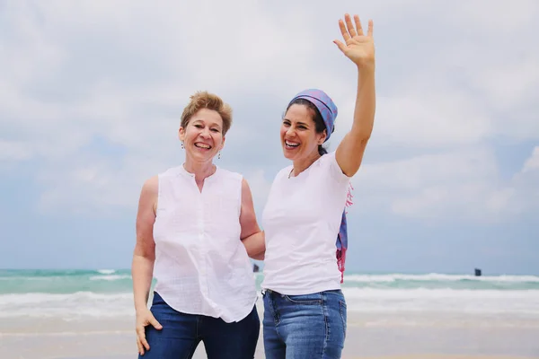 Dos mujeres de pie en la playa — Foto de Stock