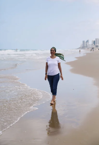 Mogen kvinna promenader vid havet — Stockfoto