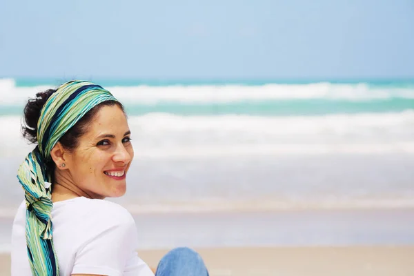 Reife Frau sitzt am Meer — Stockfoto