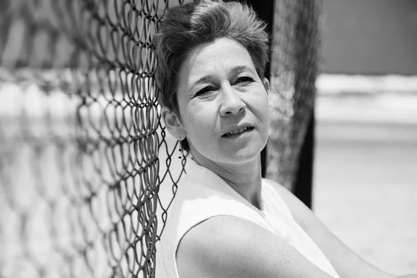 Mature woman sitting on seaside — Stock Photo, Image