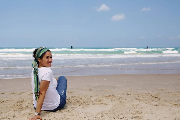 Sahil üzerinde oturan Olgun kadın — Stok fotoğraf